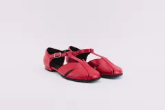 Zapatos bajos rojos de cuero con correa y hebilla.