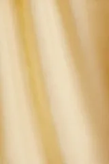 Top color amarillo pálido con breteles finos y ribete de volados en el escote.