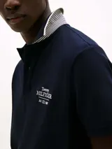 Chomba azul marino de algodón orgánico con logo de Tommy Hilfiger bordado en el pecho. Tiene cuello clásico con detalles en blanco y corte regular.