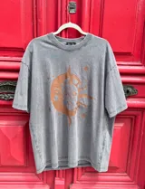 Remerón gris de corte oversize con estampado de sol, luna y estrellas en color naranja.