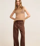 Pantalón wide leg color marrón chocolate, confeccionado en sarga de algodón y lyocell, con cintura alta, trabillas, cierre con botón y cremallera, y bolsillos tipo carpintero. Presenta botones color carey en los bolsillos delanteros.
