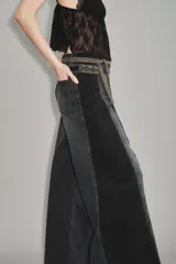 Jean de corte wide leg en color negro, con diseño de paneles laterales en un tono ligeramente más oscuro. Presenta cintura media y cierre frontal con botón y cremallera.