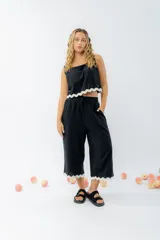 Top de lino color crudo, con escote cuadrado y detalle de guarda ondulada negra en el ruedo.