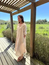 Vestido camisero amplio y largo de lino color azul, con botones de nácar, cuello camisero y bolsillos laterales.