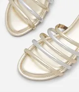 Sandalia plana tipo mule con tiras acolchadas en tonos dorado y plateado alternados, puntera cuadrada y suela plana.