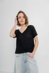 Remera tejida de manga corta, color gris claro, con escote en V y calce relajado. Presenta terminaciones acanaladas en mangas y ruedo.