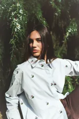 Camisa celeste con bordado de flores, corte clásico, cuello camisero y cierre frontal con botones.