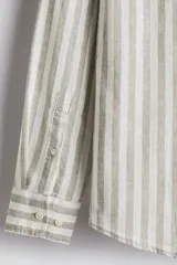 Camisa de manga larga con cuello inglés, a rayas verticales grises y blancas, con bolsillo en el pecho.