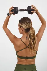 Top deportivo color beige con banda inferior azul y tirantes finos azul marino. Espalda cruzada con doble tira.