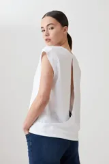 Remera blanca de corte recto, con escote en V y mangas cortas. Presenta detalle de abertura en la espalda.