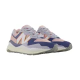 Championes urbanos New Balance modelo W5740, de mujer, con capellada de gamuza y malla en tonos lila, rosa, naranja y azul. Presentan el logo "N" característico en blanco con borde naranja y entresuela de goma blanca con suela gris.