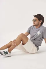 Bermuda de gabardina color crudo, corte recto y largo a la rodilla.