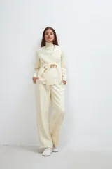 Chaqueta corta color beige, entallada, con escote en V, manga larga y cierre frontal con lazo fijo. Confeccionada en lana fina sin teñir, con bolsillos escondidos y terminaciones enviadas. Hecha 100% en Uruguay.