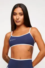 Top deportivo verde con detalles en blanco, logo minimalista y tirantes ajustables. Fabricado en poliamida y elastano con protección UV50+.