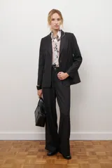 Blazer azul de jean textil, con solapa clásica, un botón frontal y bolsillos laterales.