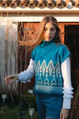 Chaleco de punto morado con cuello alto y diseño geométrico amarillo y azul.