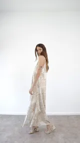 Vestido largo de tirantes finos con estampado de hojas en tonos beige y blanco.