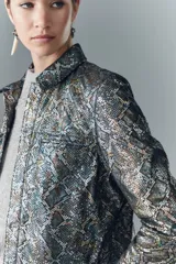 Camisa de cuero ovino con estampado reptil multicolor y detalles metalizados. De corte recto, con bolsillos tipo ojal y botones a presión con logo Rapsodia.