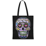 Bolso tote negro con estampado frontal de una calavera de azúcar (calaca) estilo graffiti, predominantemente morada, con corazones en los ojos y la palabra "EMEXEN" en la frente.