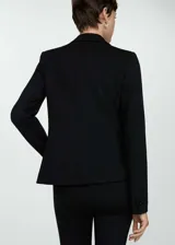 Blazer negro de corte entallado, con solapas de muesca, cierre de un botón, dos bolsillos de solapa y puños abotonados.
