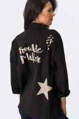 Campera verde militar de algodón con mangas largas y cuello camisero. Estampado en la espalda con la frase "Trouble Maker" y una estrella.