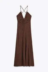 Vestido midi marrón de lino con escote en pico, tirantes finos con abalorios cruzados en la espalda y cierre lateral con cremallera oculta.