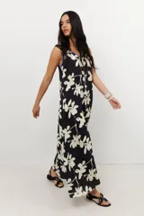 Vestido largo negro con estampado floral blanco, escote en V y corte holgado.