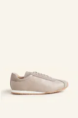 Zapatillas deportivas de cuero color borgoña con detalles en gamuza al tono, cordones finos y suela de goma blanca.