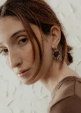 Aros colgantes con forma circular, hechos de resina color lila y borde de strass plateado. El aro es de acero quirúrgico plateado.