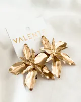 Aros colgantes dorados con forma de flor.