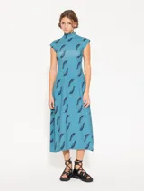 Vestido midi celeste con estampado de plumas negras, cuello alto y mangas cortas.
