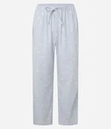 Pijama largo de sherpa color blanco, compuesto por un buzo de cuello redondo y mangas largas con estampa de una carita sonriente y un pantalón con estampa de lunares.