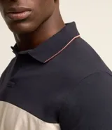 Polo de hombre de corte regular, confeccionada en algodón, con cuello clásico, mangas cortas y diseño de bloques de color: azul marino en la parte superior, blanco en el centro y rojo borgoña en la parte inferior.