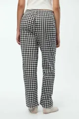 Pantalón de pijama con estampado en cuadros blancos y negros, cintura elastizada y cordón de ajuste.