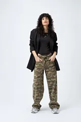Pantalón de tiro bajo con estampado camuflado, confeccionado en tela liviana de calce amplio. Su diseño incorpora cintura regulable con cordón y bolsillos utilitarios.