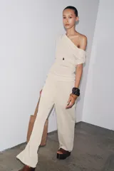 Pantalón de punto color beige, de tiro alto con cintura elástica ajustable con cordones y corte ancho.