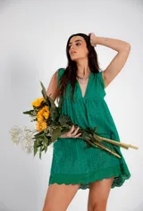 Vestido corto blanco de algodón con bordado tipo broderie anglaise, escote en V y mangas cortas con volado. Presenta un corte imperio con frunce bajo el busto.