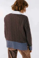 Sweater color camel con tejido de trenzas y terminaciones en color beige.