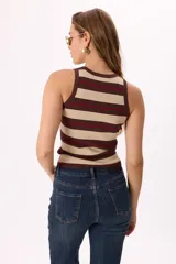 Musculosa tejida a rayas horizontales en blanco y negro, con detalles en rojo y cuello redondo.