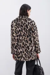 Tapado cruzado oversize confeccionado en paño con estampado de leopardo, con botones frontales y bolsillos aplicados.