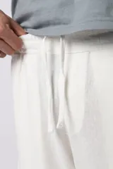 Bermuda cargo color blanco, confeccionada en mezcla de lino y rayón, con cintura elástica ajustable con cordón y bolsillo lateral tipo cargo.