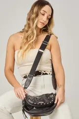 Bandolera de cuero celeste con correa de cinta regulable, forro de algodón, cierre central y bolsillo trasero con cierre.