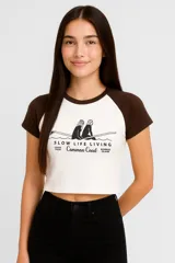 Remera corta blanca con mangas raglán grises y estampado frontal con texto 'Venice Beach California Where life's a beach'.