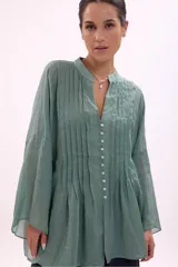 Camisa verde agua con cuello mao, abotonada al frente y mangas largas acampanadas con detalle de pinzas verticales en el frente.