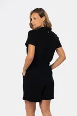 Mono corto color beige de lino, con cuello camisero, cierre frontal con botones, cinturón de lazo y bolsillos laterales.