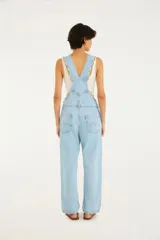 Enterito largo de jean celeste con tirantes ajustables con hebillas metálicas, bolsillo frontal y corte amplio.