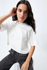 Remera negra de corte holgado con mangas ranglan y cuello redondo con bordado de estrellas blancas.