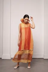 Vestido largo y amplio con cuello alto y mangas cortas abullonadas. Diseño a rayas verticales en tonos dorado y gris. Incluye viso liso al tono.