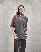 Remera gris oscuro con efecto acid wash, corte holgado y mangas cortas. Cuello redondo. Falda midi de encaje floral negro con abertura frontal.