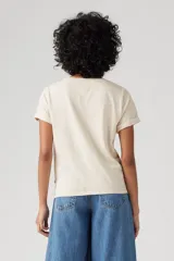 Remera color crudo de corte recto, con cuello redondo y mangas cortas con dobladillo. Tiene un bolsillo en el pecho con bordado de una flor.